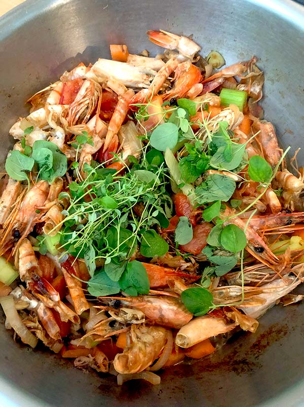 Cooked prawn shells and vegetables with fresh herbs