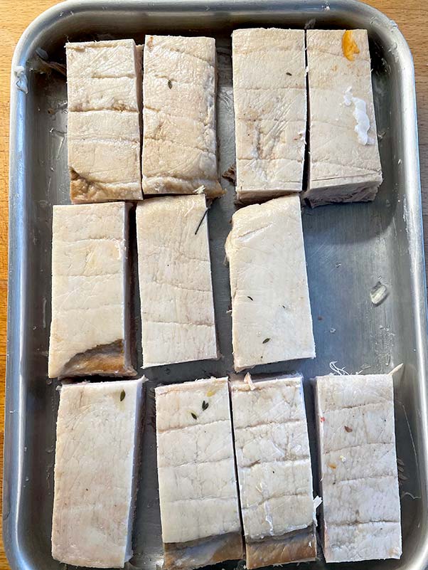 Pressed pork belly cut into pieces ready to fry off_