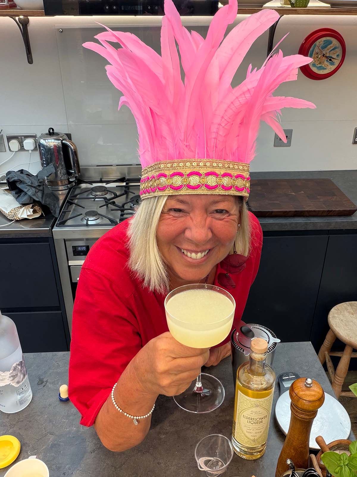 Jules with a cocktail, wearing feathers